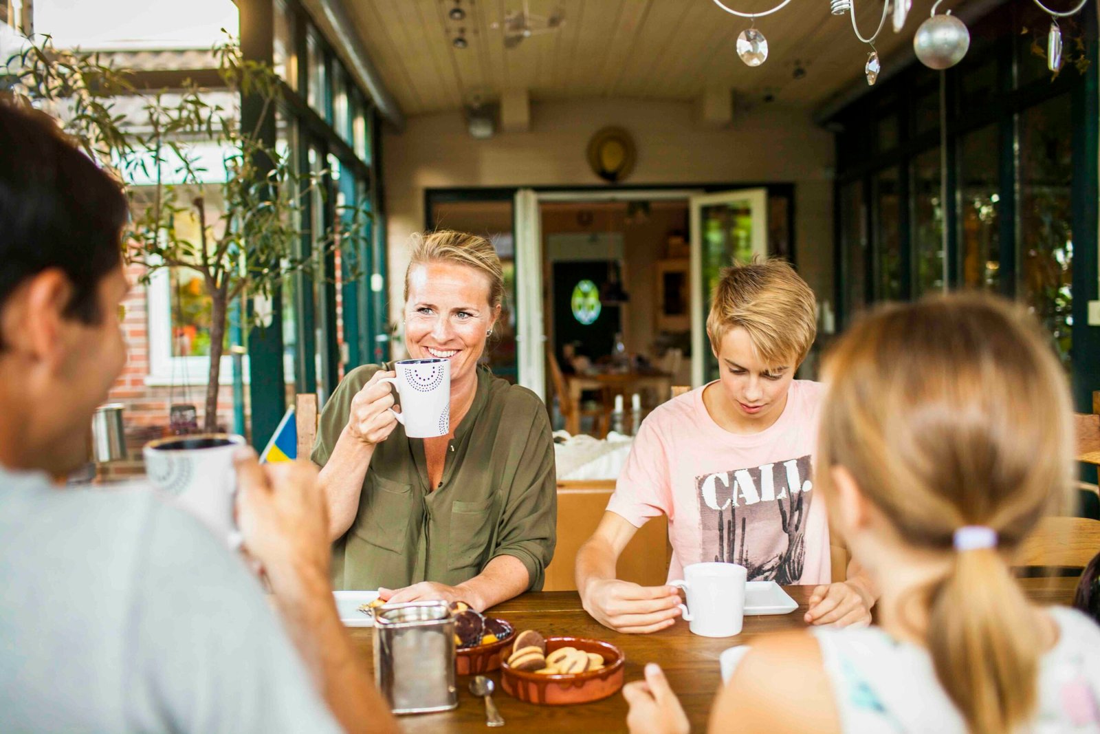 Happy parents with children enjoying art of small talk and having breakfast at home